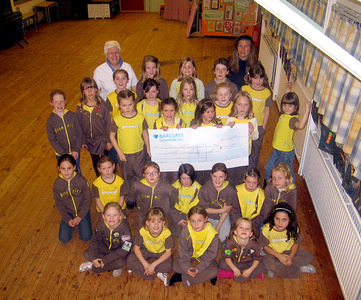 The St Martin's Hall Brownies donate the proceeds from walking backwards around The Green...